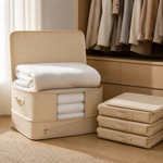 Beige collapsible bedding storage bag open with folded blankets and three bags stored flat