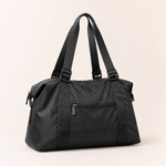 Black travel duffel bag with handles and shoulder strap on a clean background