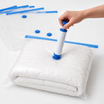 Manual hand pump connected to a vacuum storage bag containing folded bedding